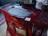 a red stove sitting on a pallet in a garage