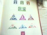 un livre avec des timbres sur les pages et un stylo sur la table