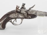 un vieux pistolet avec un homme assis dessus