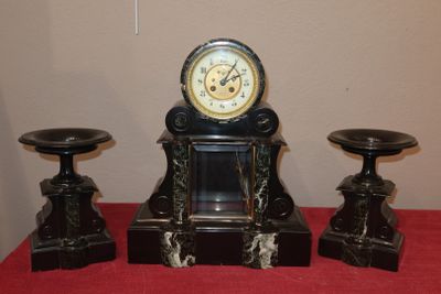 une horloge posée sur une table à côté de deux tabourets