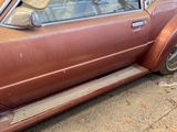 a rusted car parked on the side of the road