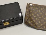 une mallette et un portefeuille Louis Vuitton posés sur une surface blanche