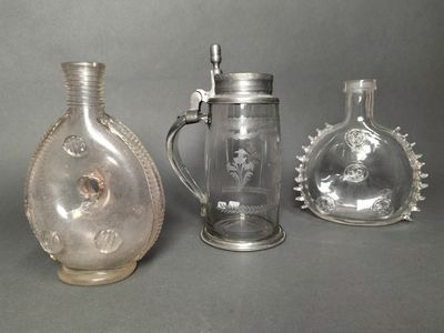 three glass vases and a glass pitcher sitting on a table