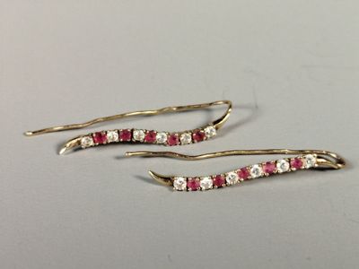 pair of ruby and diamond earrings on a white surface