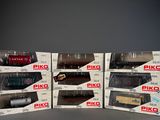 six boxed boxes of various model trains sitting on a table