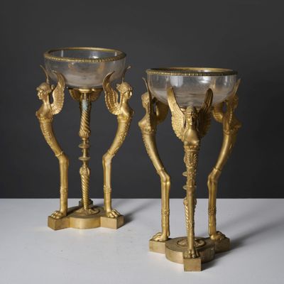 pair of gold - plated vases with birds on them on a white surface
