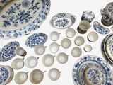 many different types of blue and white plates and bowls on the table