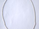 a close up of a necklace on a white surface with a white background