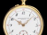 gros plan d'une montre de poche en or sur fond noir