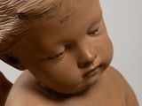 a small statue of a baby holding a teddy bear