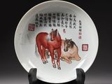 a white plate with a painting of two horses on it