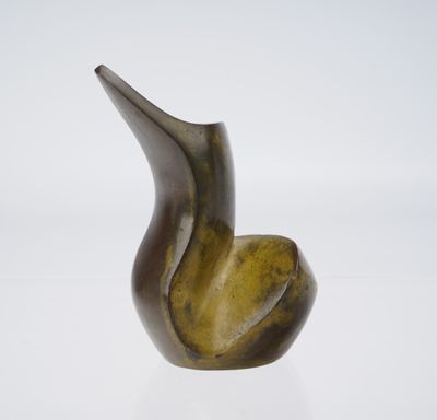 sculpture en bronze représentant un oiseau sur une surface blanche, avec un fond blanc