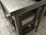 stainless steel counter top in a commercial kitchen with two pots on it
