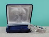 une photo représentant une montre et une bague dans un coffret