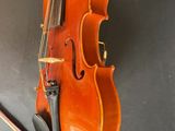 an orange violin sitting on top of a table next to a bow