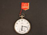 une montre de poche en argent sur laquelle est accrochée une étiquette rouge