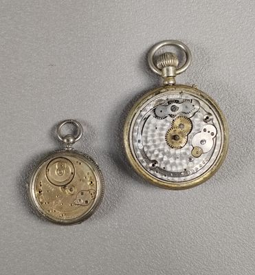 Deux types différents de montres de poche sont présentés sur une surface grise