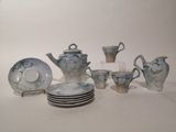many plates and cups and a teapot on the table