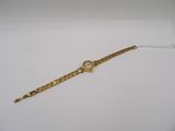 a close up of a gold watch on a white surface