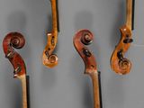 three old violin strings hanging on a wall in a room