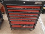 two red drawers are stacked on top of each other in a garage