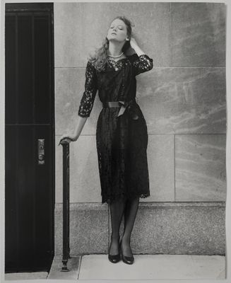 photographie en noir et blanc d'une femme adossée à un mur