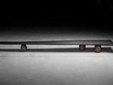 un banc en béton dans une pièce sombre, éclairé par une lumière