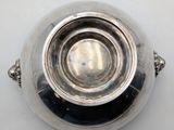 a silver bowl on a table with a white background