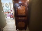 une grande armoire en bois dans un coin du couloir