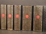 four books are lined up in a row on a table