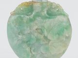 un vase vert surmonté d'un oiseau