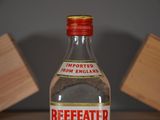 a bottle of beeffeathr sitting on a table next to a block of wood