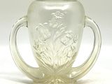 un verre muni d'une anse et orné d'un motif floral