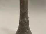 a close up of a vase on a table with a white background