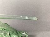 a green glass crab with a spoon in it