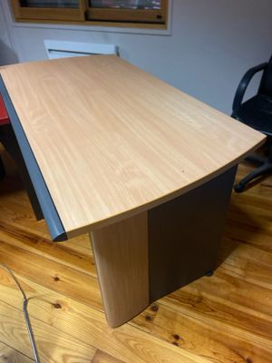 un bureau en bois avec une chaise noire dans un coin