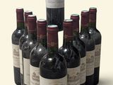 Des bouteilles de vin rouge sont disposées en pyramide sur une surface blanche