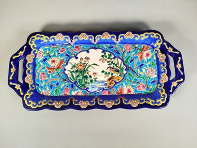 un plateau bleu orné d'un oiseau et de fleurs