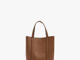 Ce petit sac fourre-tout en cuir est marron et se ferme à l'aide d'une fermeture à glissière.