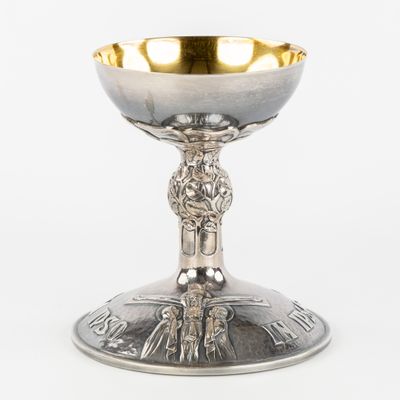 a close up of a silver cup on a white surface