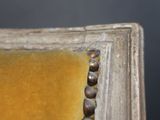 close up of a painting of a yellow chair with a beaded seat