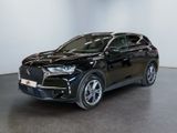 Un SUV noir est garé dans une pièce aux murs blancs.