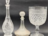 three glass vases and a decanter sitting next to each other