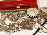 une boîte rouge remplie de nombreux bijoux, posée sur une table