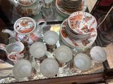 a glass table with a lot of dishes and cups on it