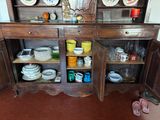 a china cabinet with many plates and bowls on it