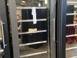 two refrigerators that are open in a store