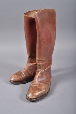 une paire de bottes de cow-boy en cuir marron sur fond gris