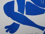 a blue and white sign with a woman sitting on it