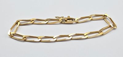 gros plan d'un bracelet en chaîne en or sur une surface blanche